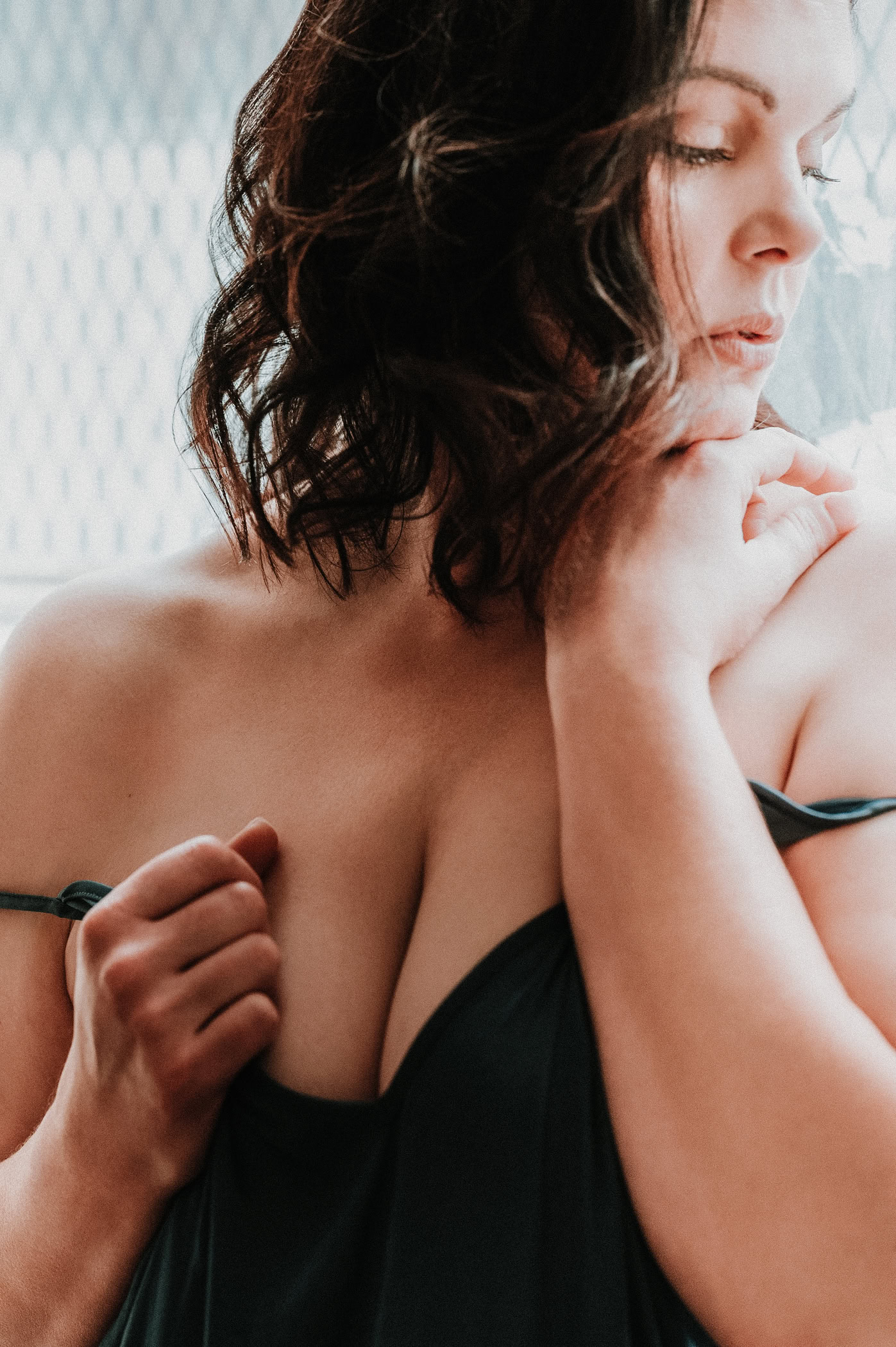 A mature woman in front of the window light showcasing bold and mature beauty