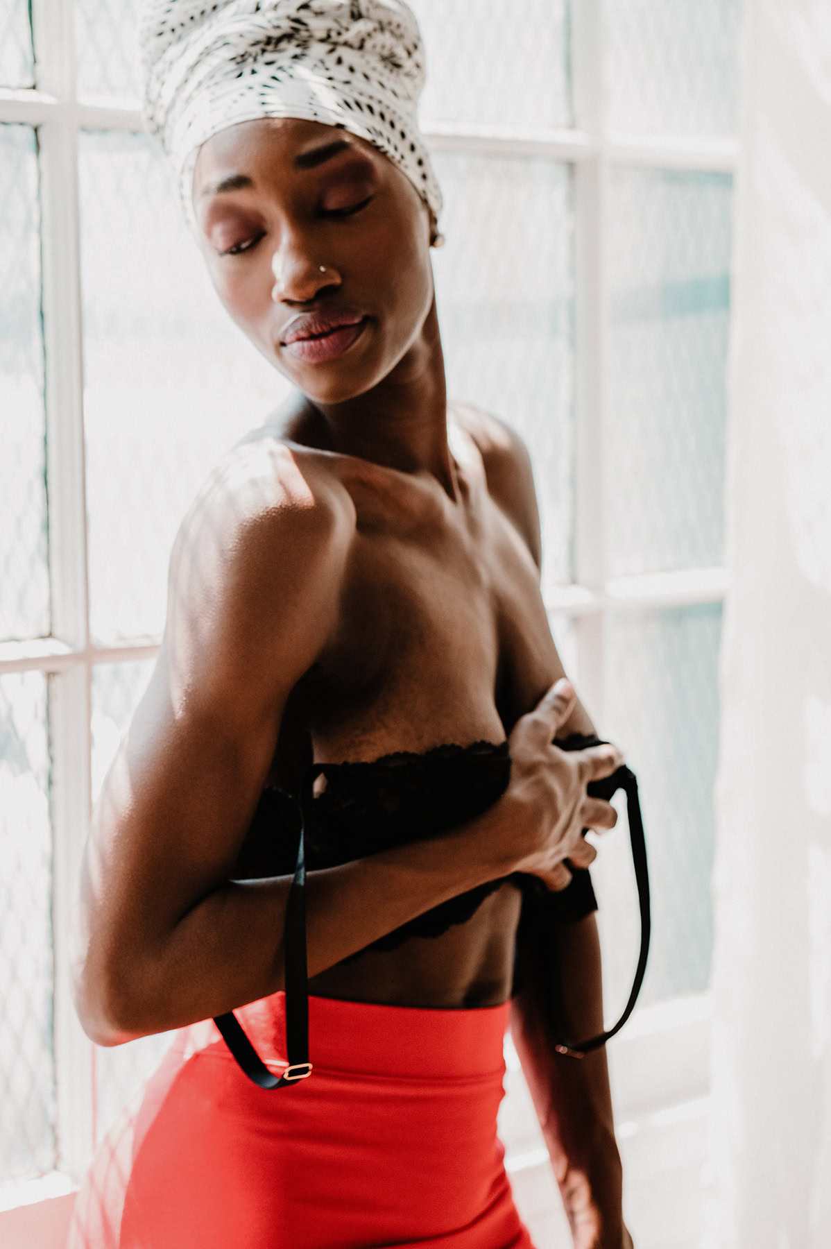 Bright and colorful black woman in a soft boudoir portrait setting