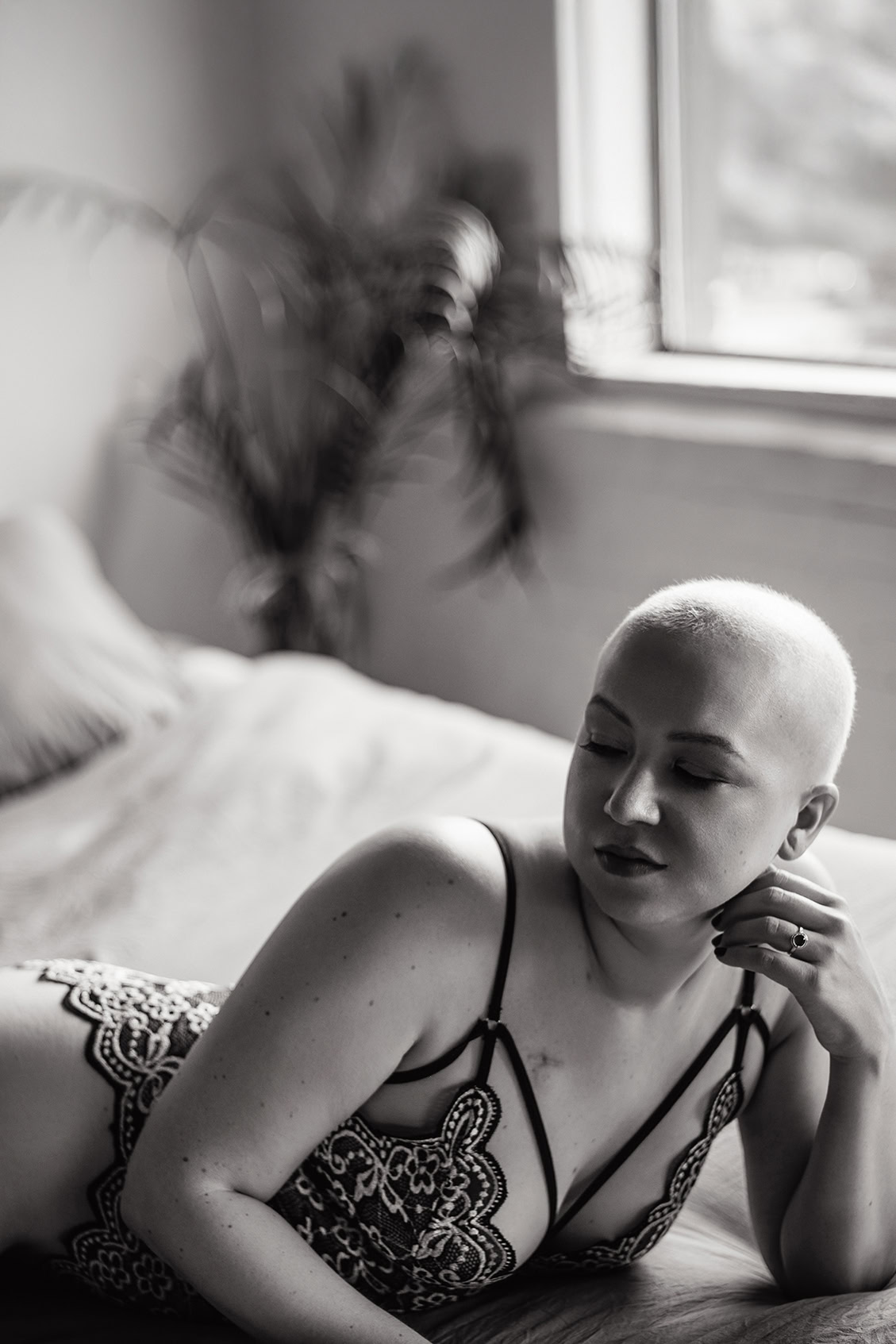 A radiant boudoir session with a bald cancer survivor embracing confidence after chemotherapy
