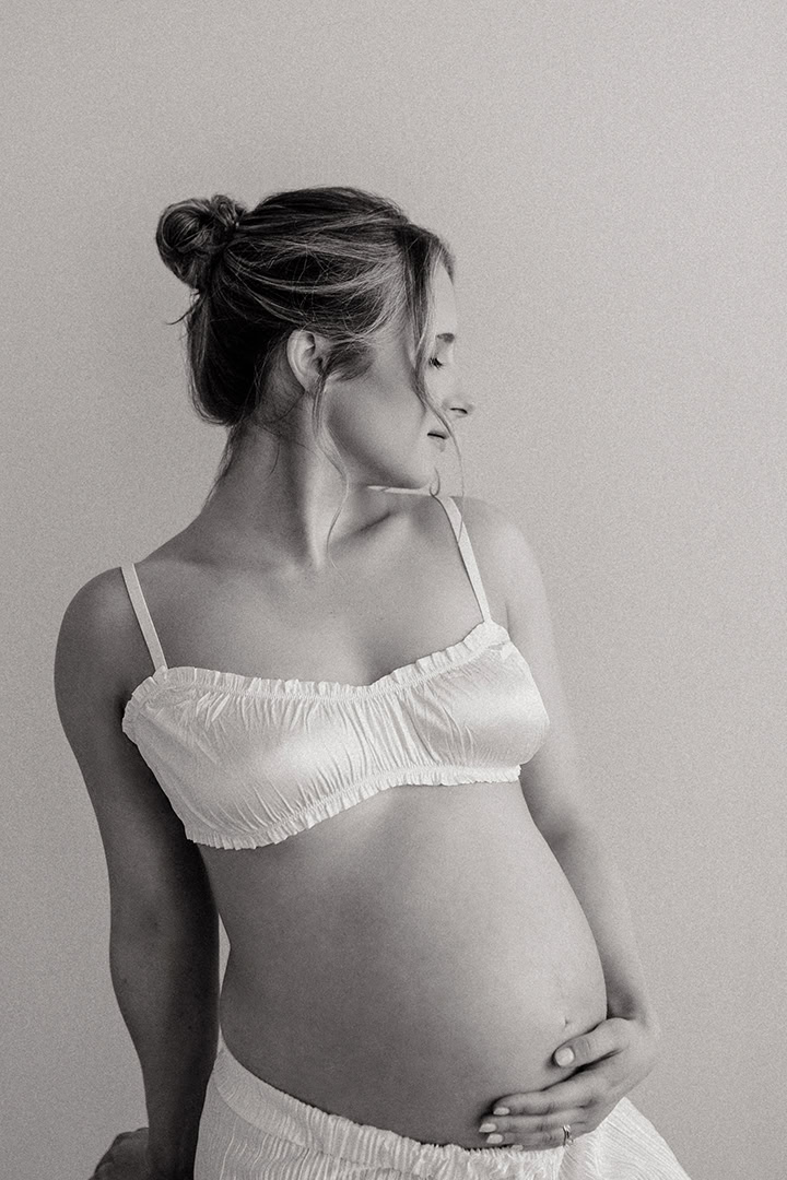 Expecting couple embracing during an intimate maternity photography session.