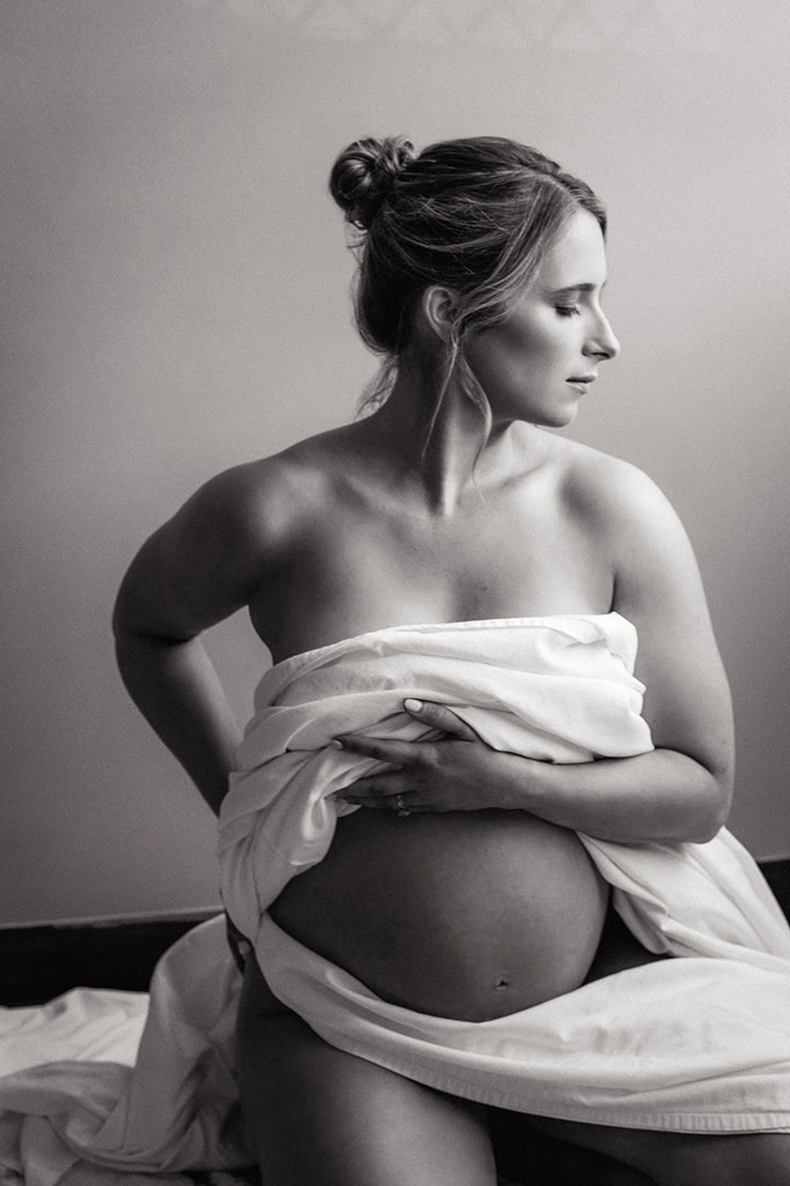 Pregnant woman photographed black and white, semi-nude in the natural light