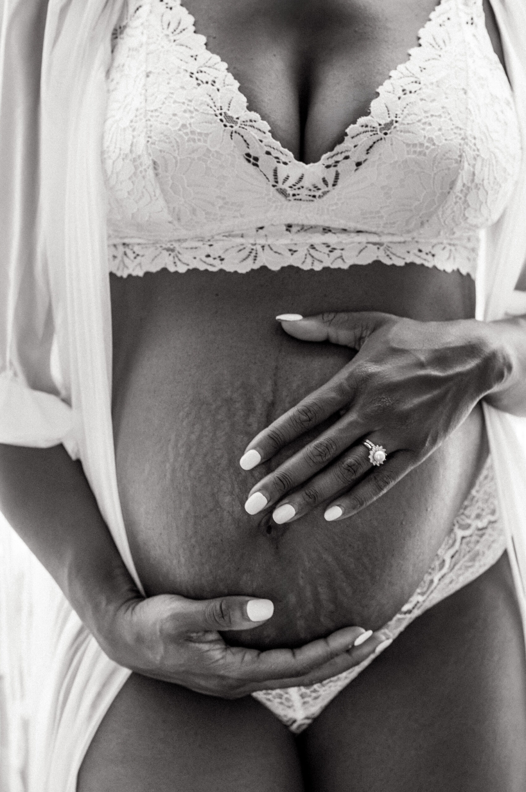Close-up maternity portrait highlighting an expecting mother’s baby bump during a boudoir session.